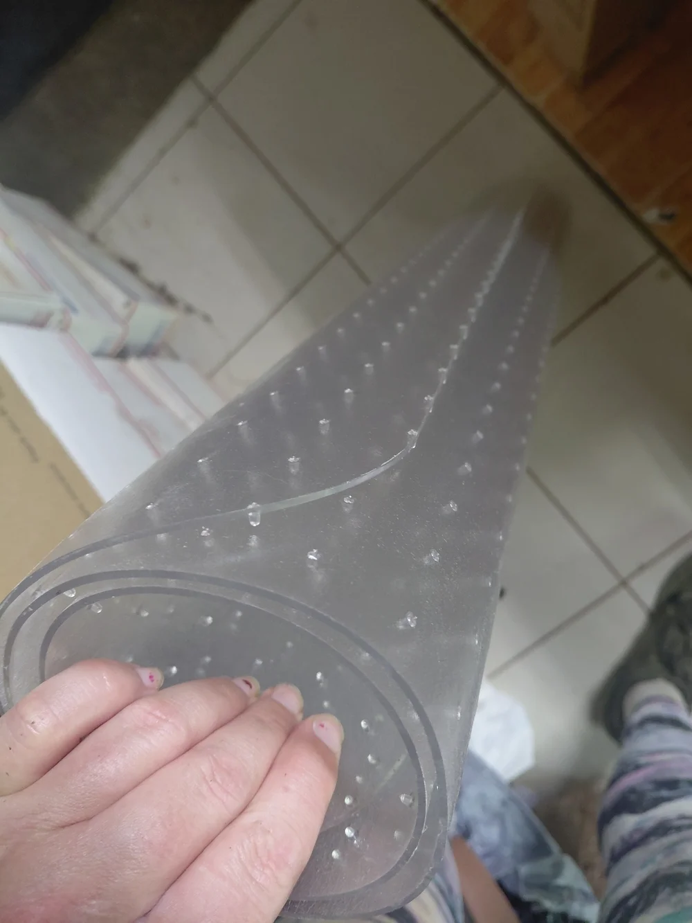 clear vinyl carpet protector with studs on the underside to prevent slipping on